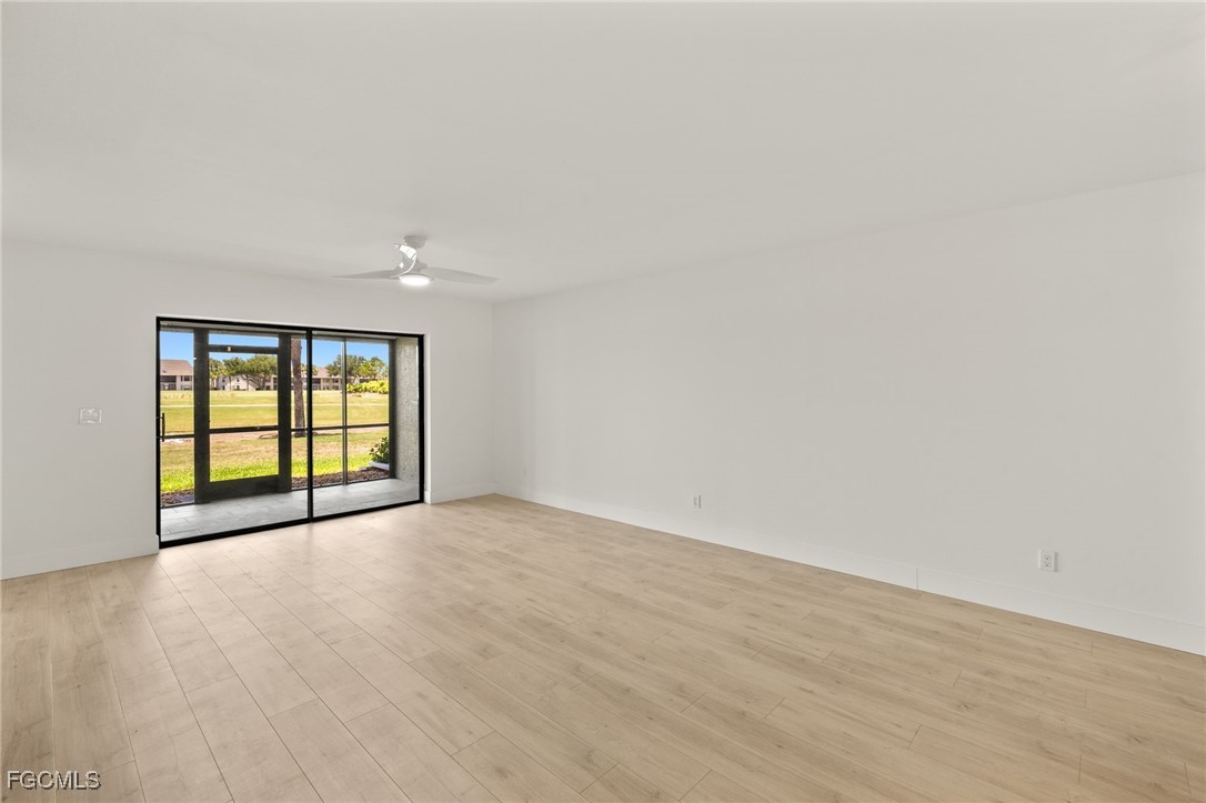 16260 Kelly Cove Drive, Unit 235 Fort Myers, FL 33908 - Photo 6 of 30 a view of an empty room with wooden floor and a window