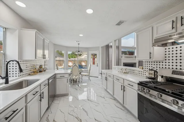a kitchen with stove a sink and cabinets