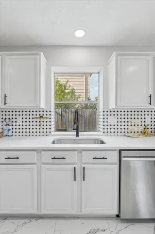 a kitchen with granite countertop white cabinets and sink