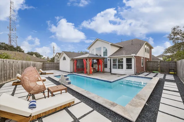 a view of a house with pool and sitting area