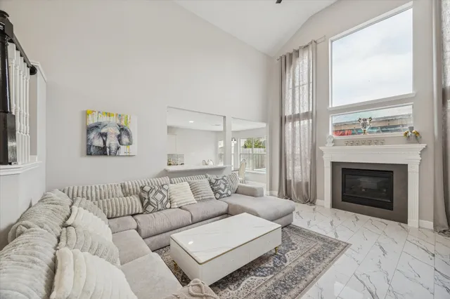 a living room with furniture a large window and a fireplace