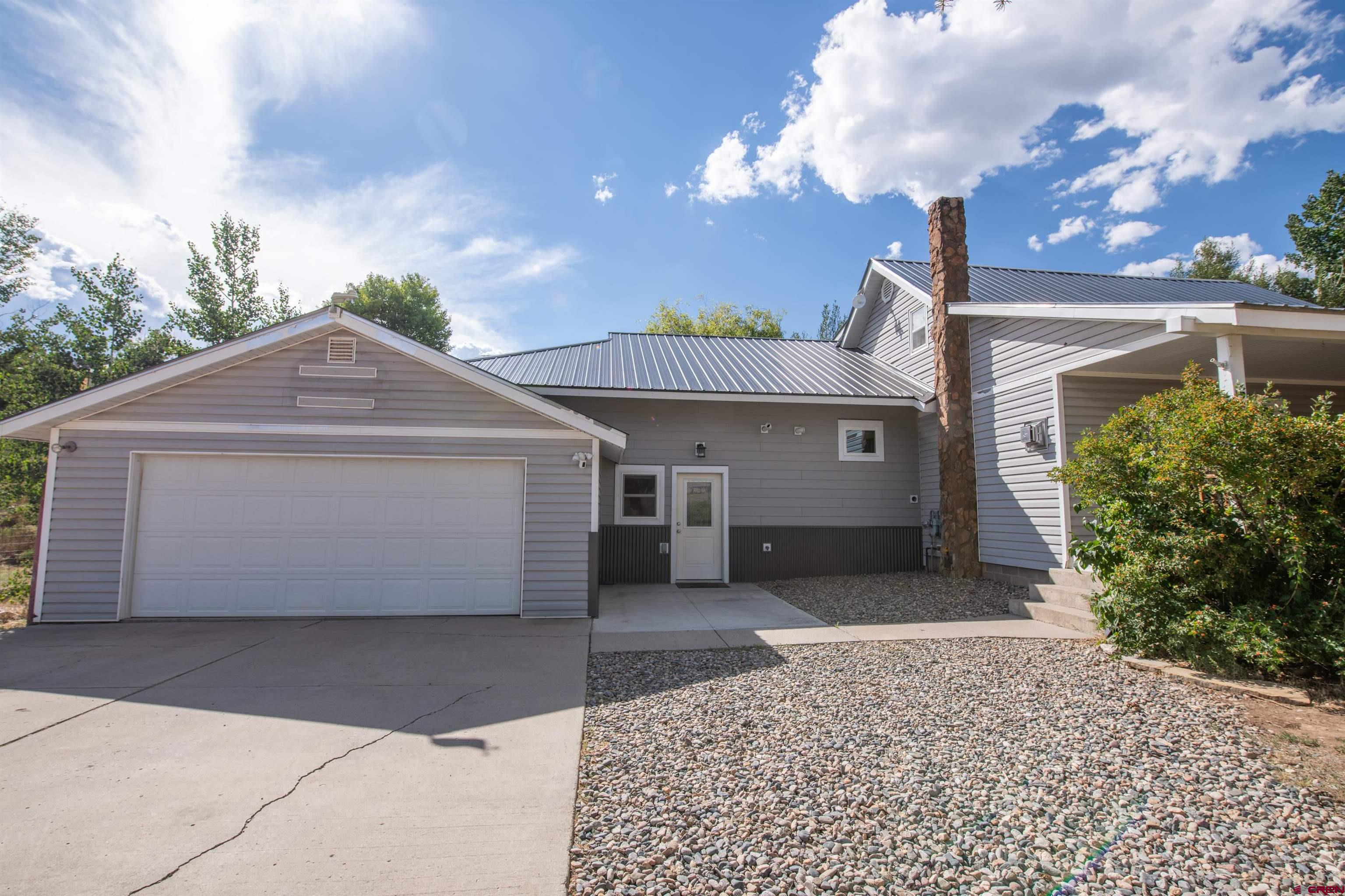 15 Debby Way Gunnison, CO 81230 - Photo 1 of 34 a front view of a house with a yard and garage