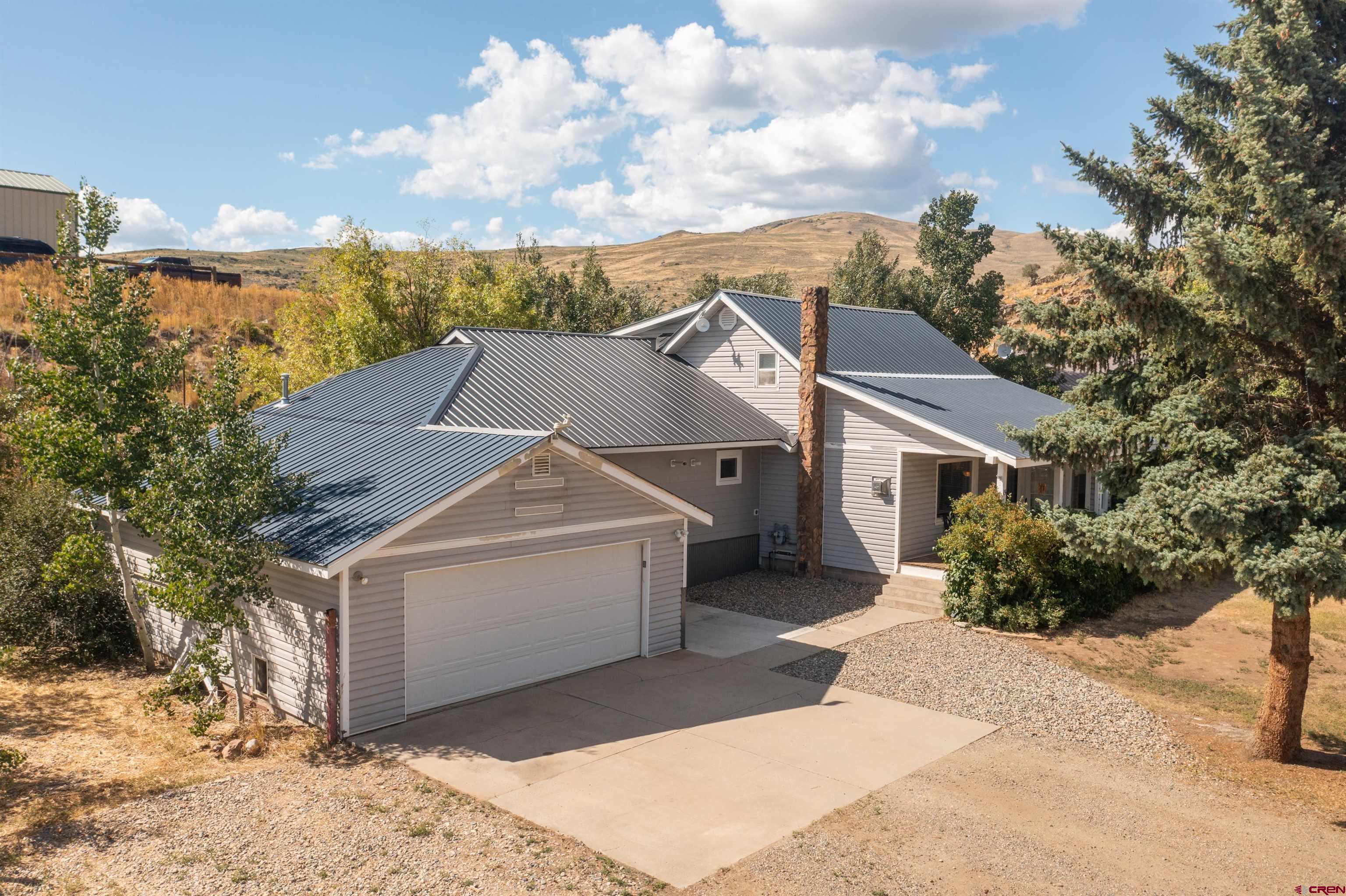 15 Debby Way Gunnison, CO 81230 - Photo 2 of 34 a view of a white house next to a yard with large trees