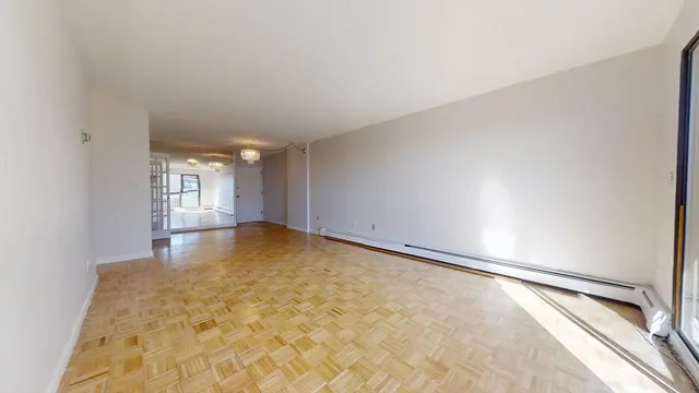 a view of empty room with wooden floor