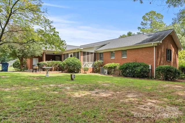 a house that has a big yard and potted plants in front of it