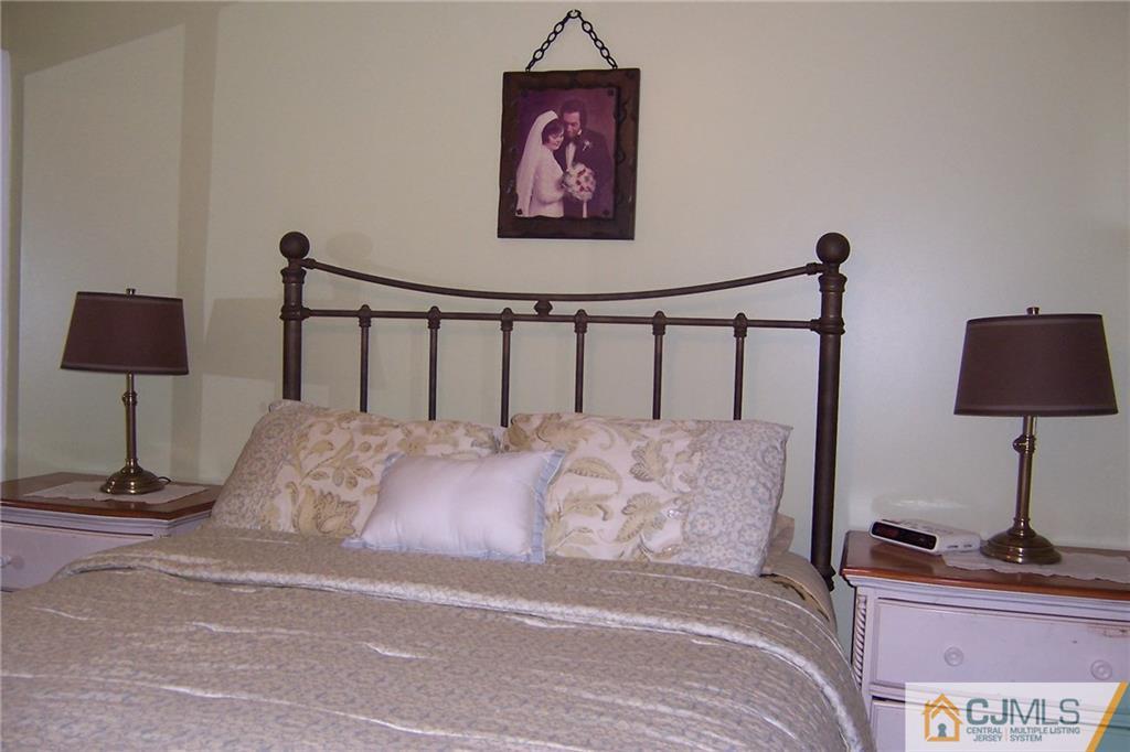 175 Midfield Road Colonia, NJ 07067 - Photo 12 of 25 a bedroom with a bed and a lamp on table