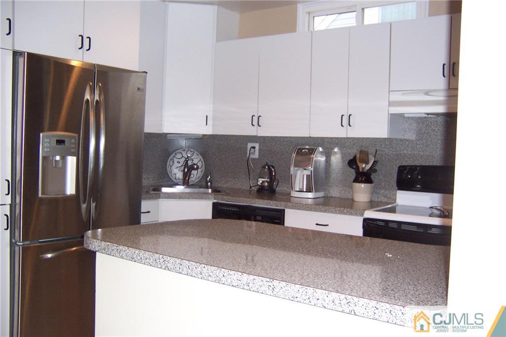 175 Midfield Road Colonia, NJ 07067 - Photo 8 of 25 a kitchen with stainless steel appliances granite countertop a refrigerator a stove a sink and white cabinets