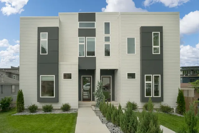 a view of a house with brick walls and a yard with plants