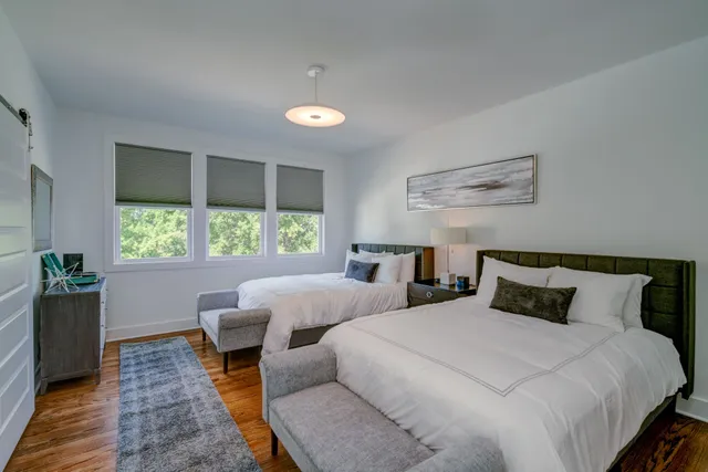 a bedroom with two beds and a large window