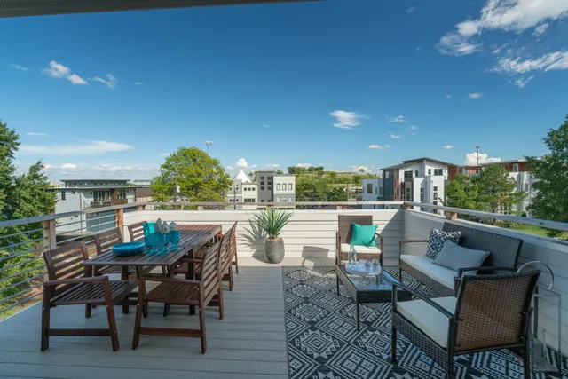 a view of a patio with a dining table and chairs with a small yard