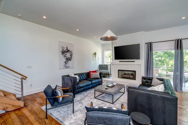 a living room with furniture a fireplace and a flat screen tv