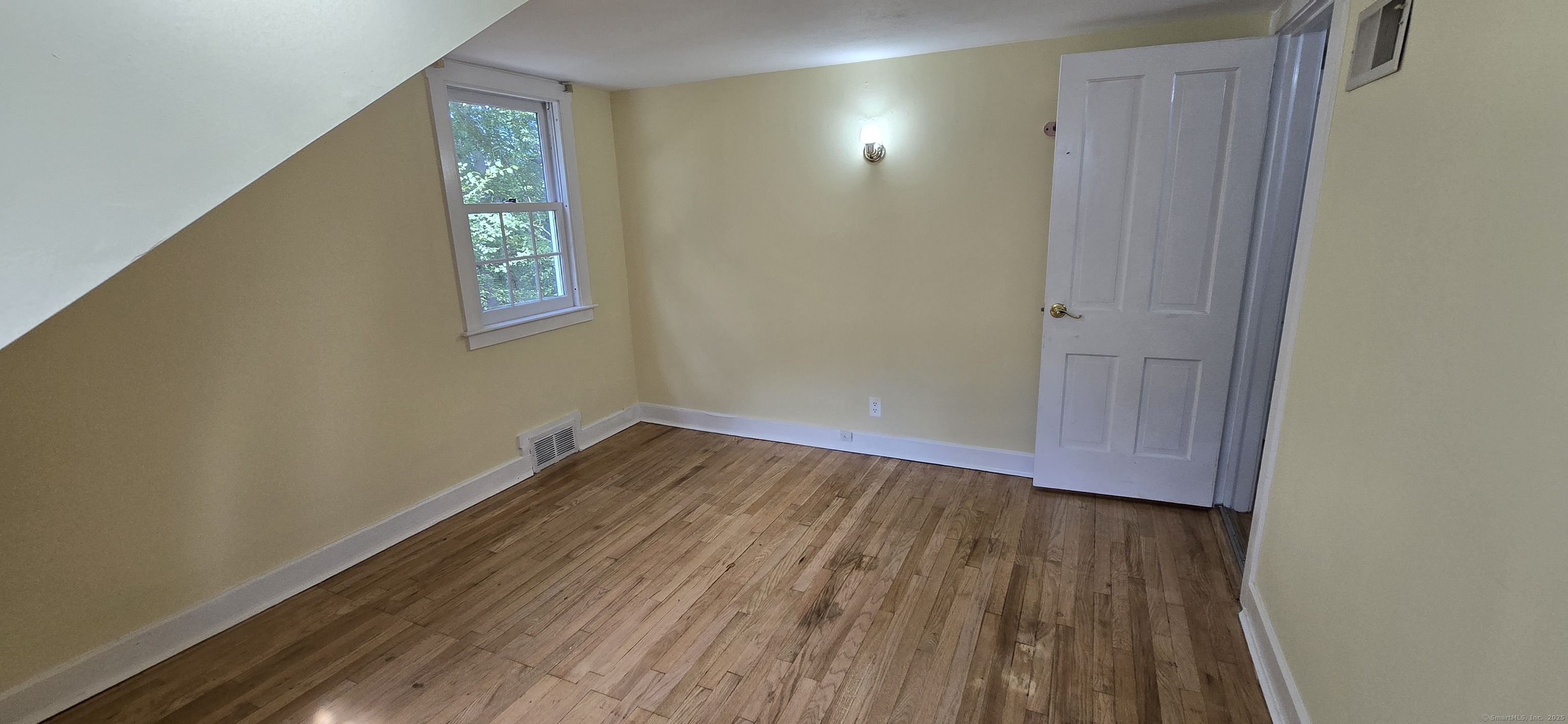 187 West Avon Road Avon, CT 06001 - Photo 10 of 40 a view of an empty room with wooden floor and a window