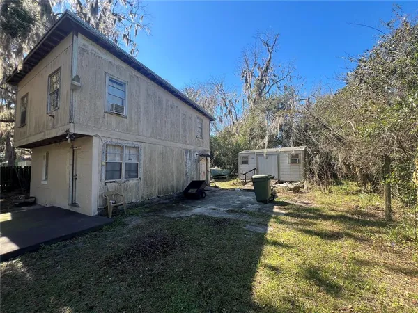 a view of a house with backyard and a tree