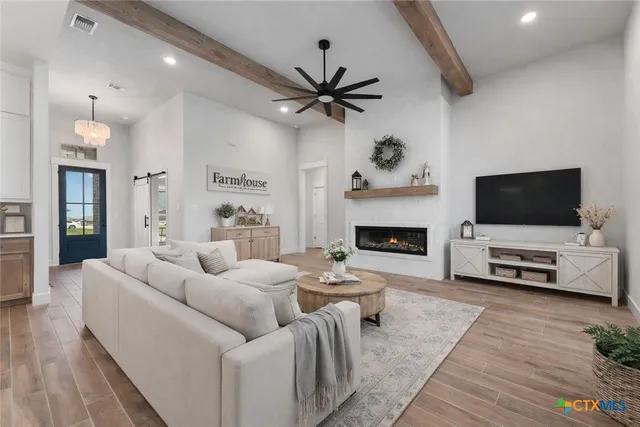 a living room with furniture a flat screen tv and a fireplace