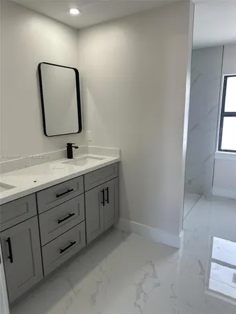 a bathroom with a sink vanity and mirror