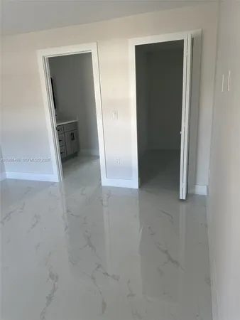 an empty room with closet and mirror