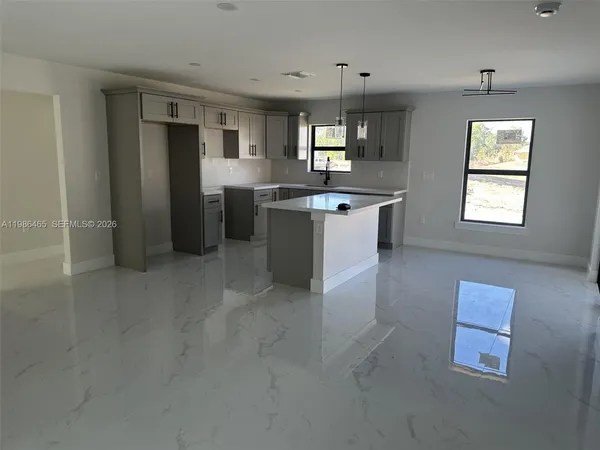 a large kitchen with lot of cabinets and refrigerator