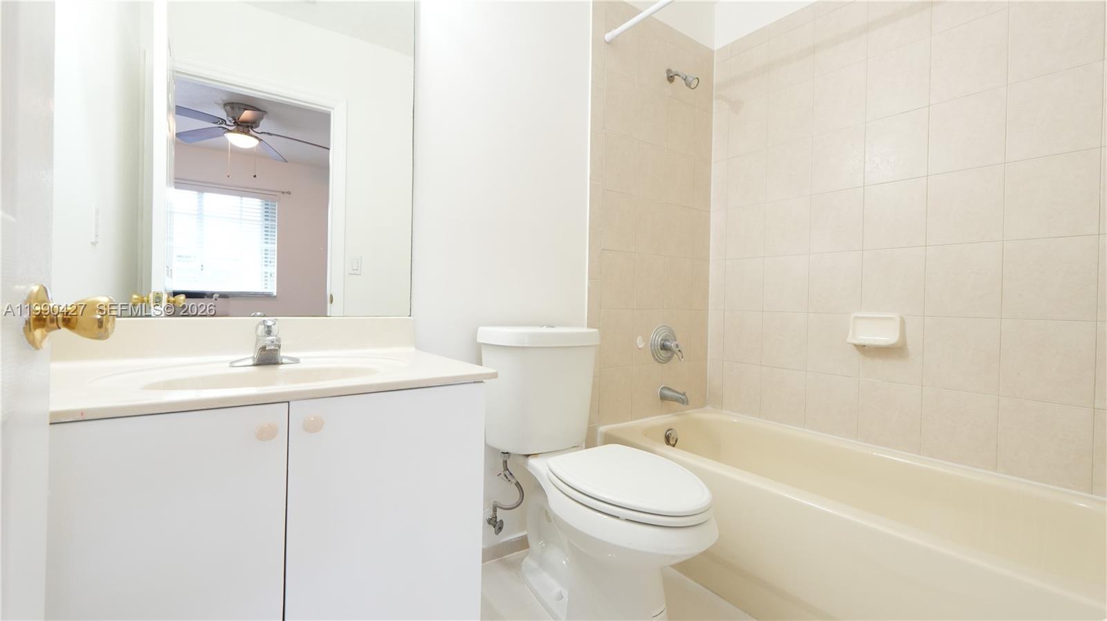 14138 Southwest 260th Street, Unit 106 Homestead, FL 33032 - Photo 4 of 12 a bathroom with a sink a toilet and shower