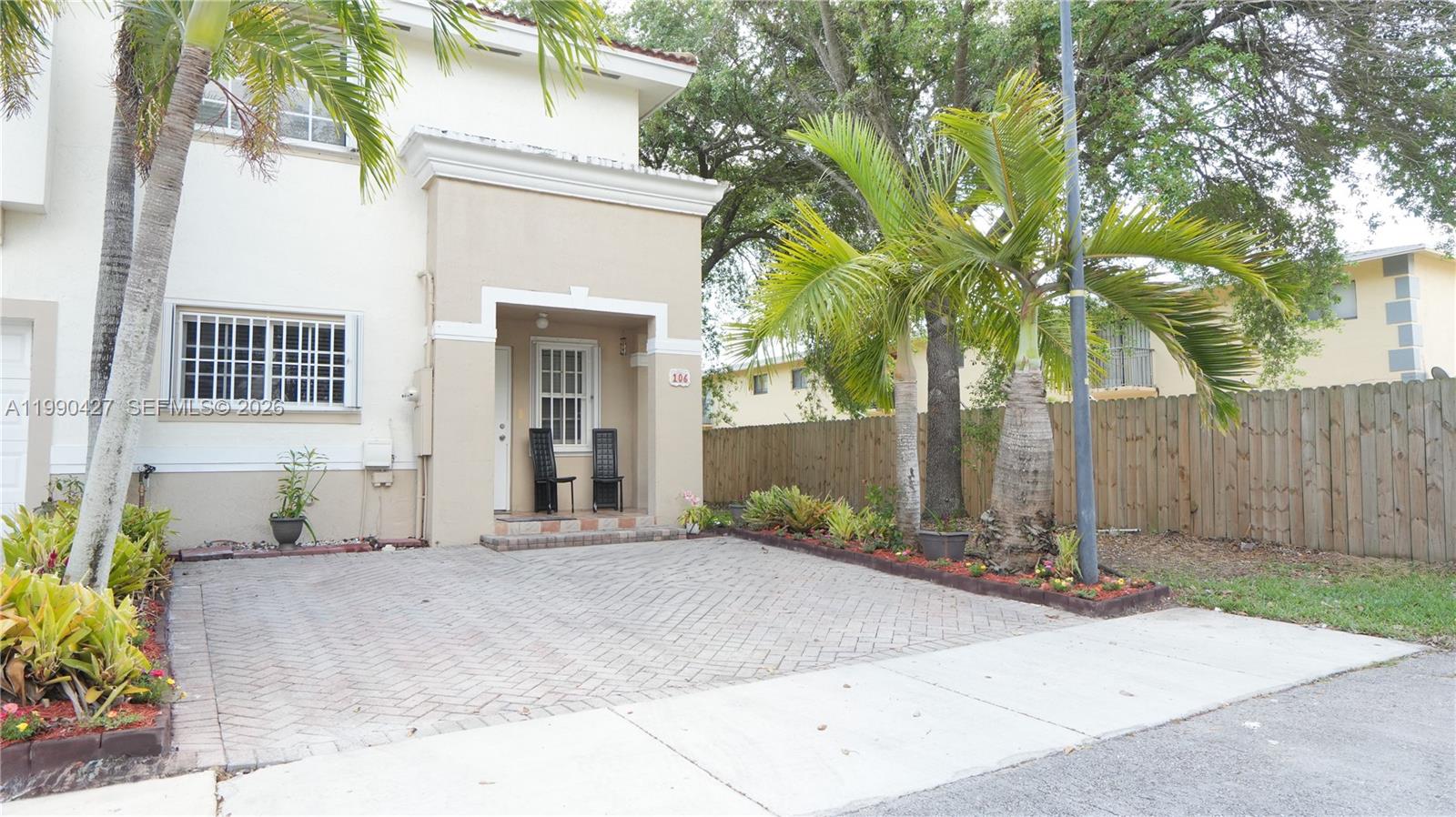 14138 Southwest 260th Street, Unit 106 Homestead, FL 33032 - Photo 8 of 12 a front view of a house with a garden