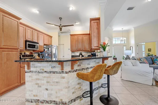 a kitchen with stainless steel appliances kitchen island granite countertop a stove a sink dishwasher a dining table and chairs with wooden floor