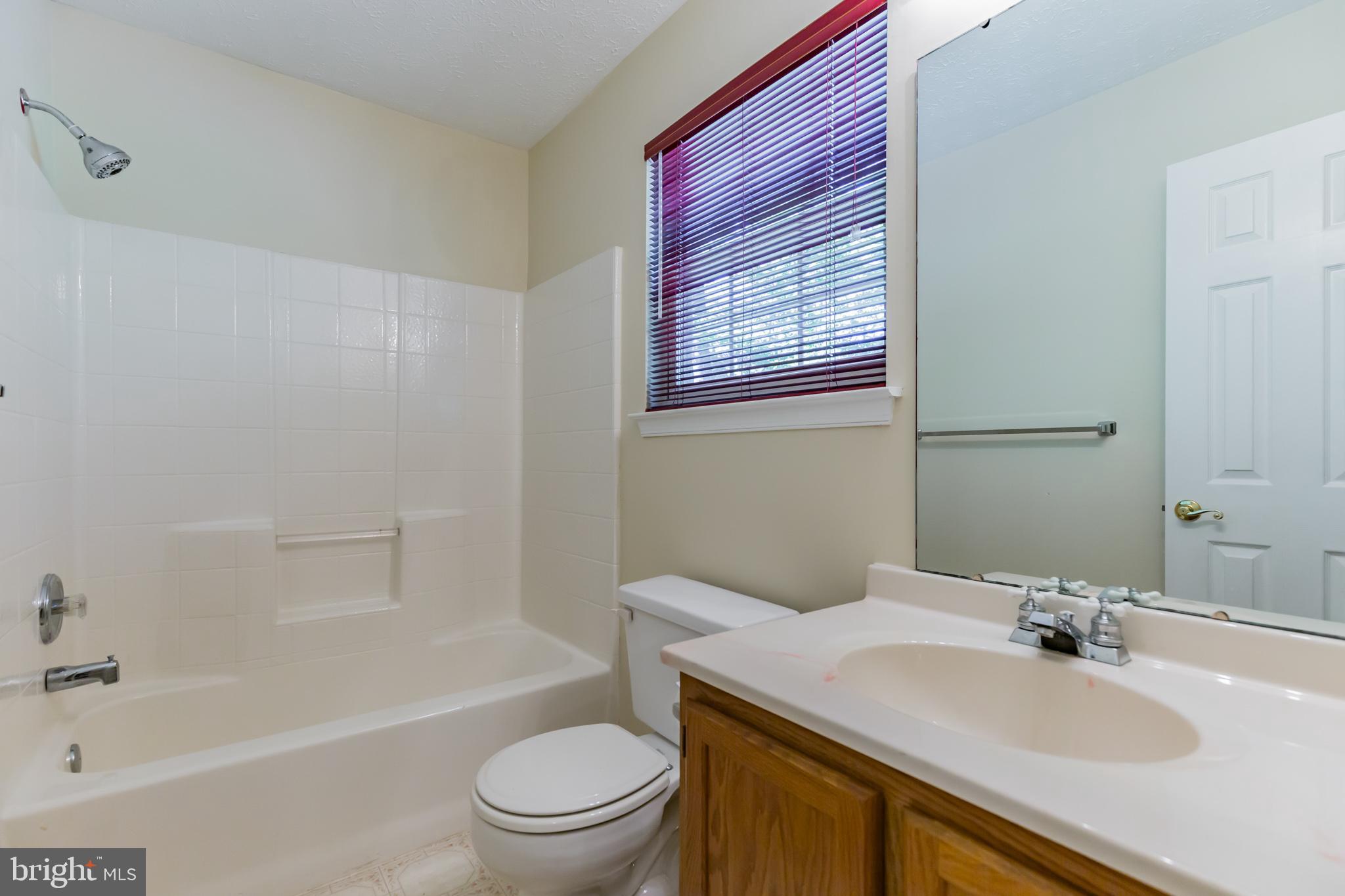 640 Small Reward Road Huntingtown, MD 20639 - Photo 8 of 28 a bath room with a toilet a sink and a bath tub
