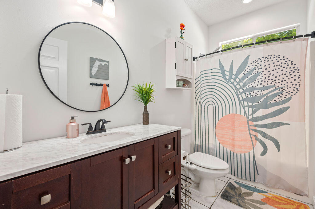 4475 New Market Road Niceville, FL 32578 - Photo 20 of 31 a bathroom with a sink a mirror a toilet and a mirror