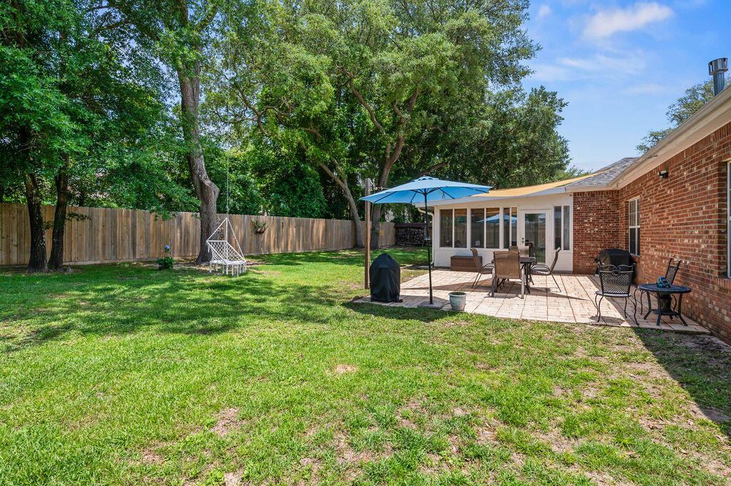 4475 New Market Road Niceville, FL 32578 - Photo 23 of 31 a view of a patio with table and chairs under an umbrella