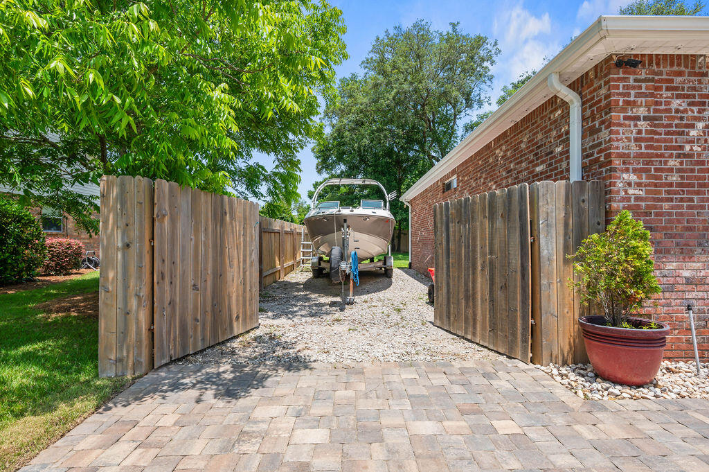 4475 New Market Road Niceville, FL 32578 - Photo 3 of 31 a view of a backyard with potted plants and wooden fence