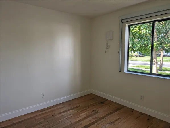 a view of a room with wooden floor and a window