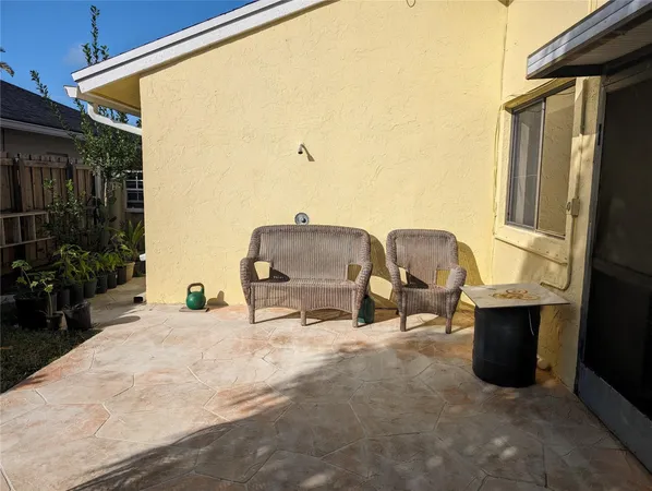 a view of roof deck with table and chairs and potted plants