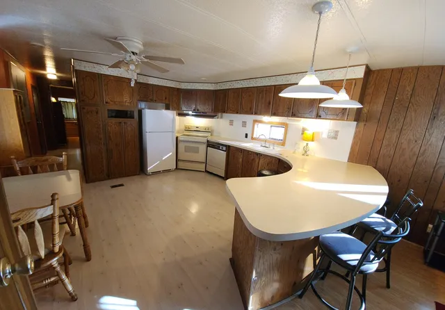 a kitchen with stainless steel appliances kitchen island granite countertop a sink cabinets and wooden floor