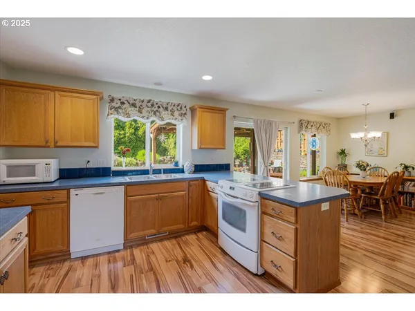 a kitchen with stainless steel appliances granite countertop sink stove and wooden cabinets