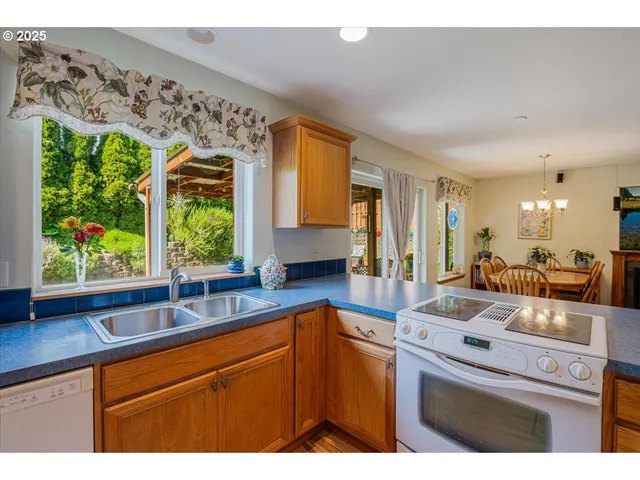 a kitchen with a sink cabinets appliances and a large window