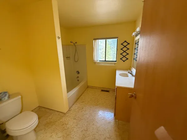 a view of an empty room with a fireplace and a window