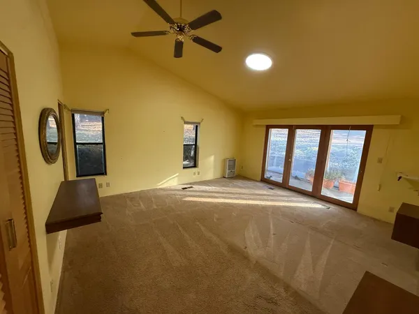 a view of a livingroom with a refrigerator and a ceiling fan