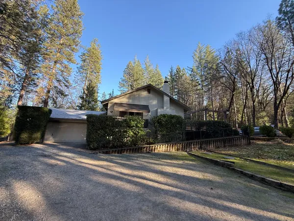 a backyard of a house with lots of plants and trees