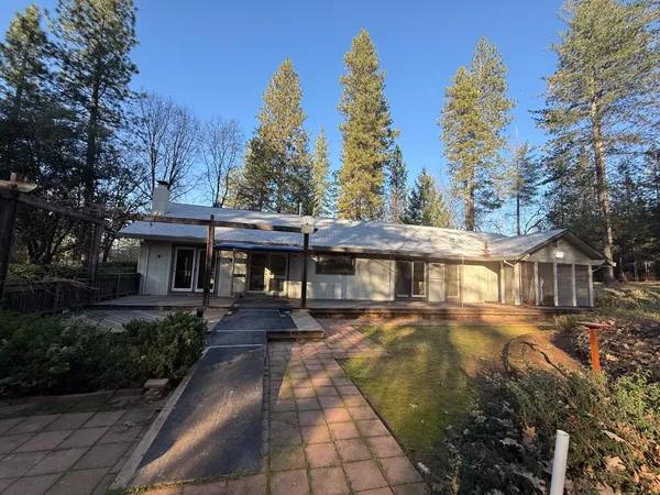 a front view of a house with trees and plants