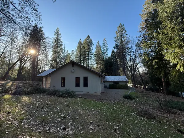 a view of a large house with a yard and large trees
