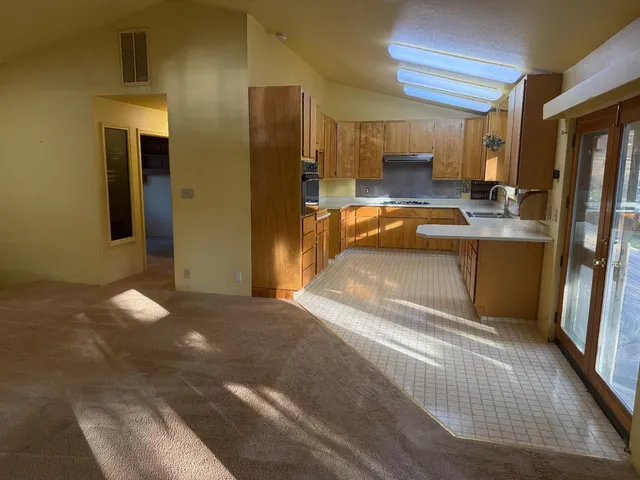 a view of a kitchen with refrigerator and a sink