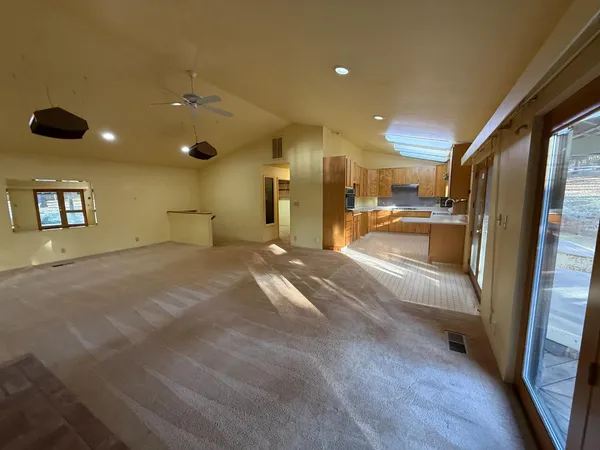 a view of large kitchen with a sink and refrigerator
