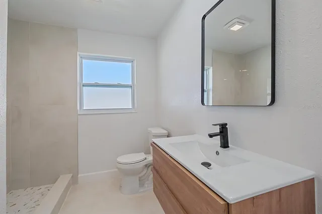a bathroom with a sink toilet and mirror