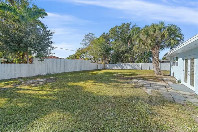 a view of yard with swimming pool and trees in the background