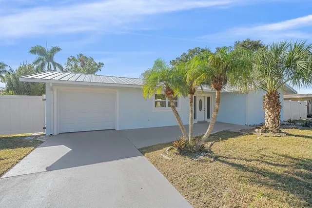 a view of a house with a yard and a garage