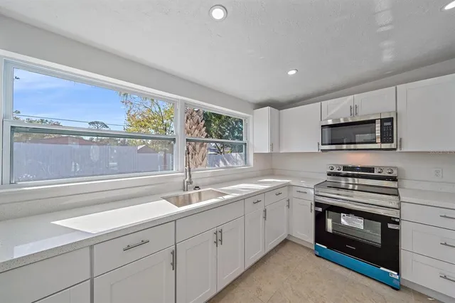 a kitchen with a sink stove and microwave