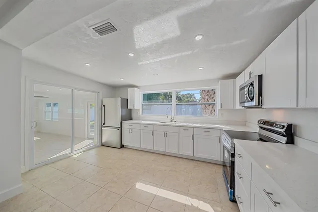 a large white kitchen with a sink