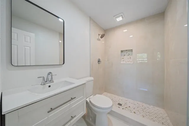 a bathroom with a sink a toilet and shower