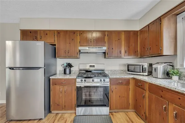 a kitchen with a refrigerator sink stove and cabinets