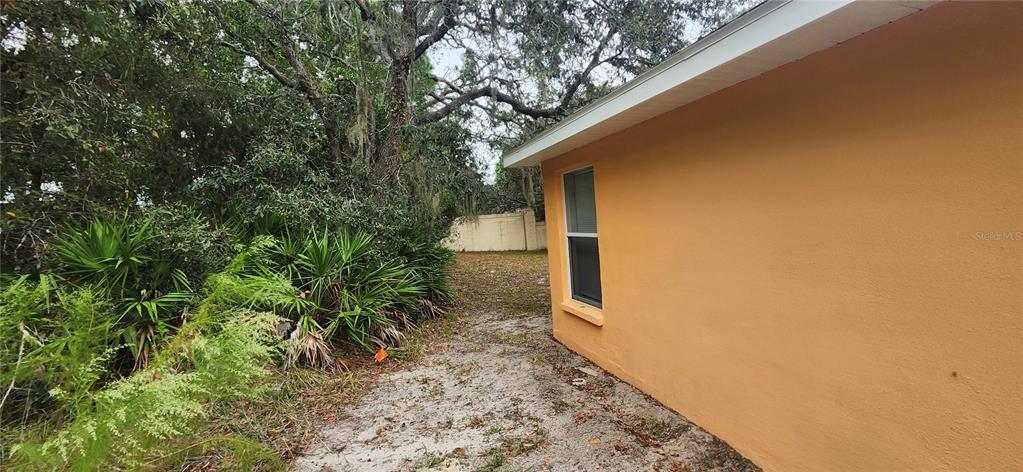 7411 Canterbury Street Spring Hill, FL 34606 - Photo 26 of 28 a yellow house with trees in front of it