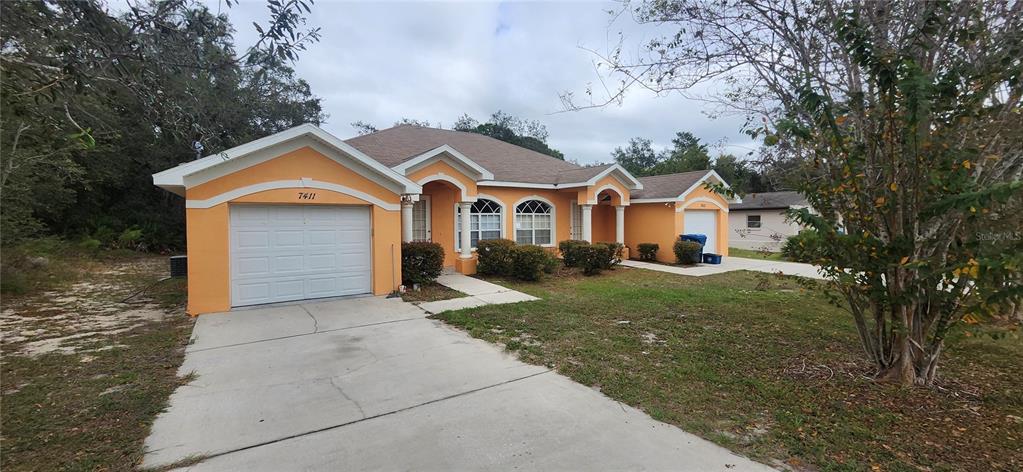 7411 Canterbury Street Spring Hill, FL 34606 - Photo 28 of 28 front view of a house with a yard