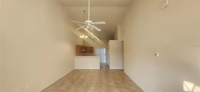 a view of a hallway with wooden floor and a chandelier